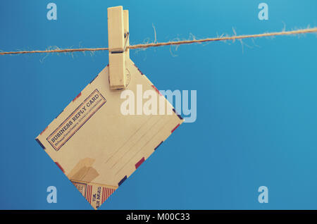 Busta del messaggio su una fune su uno sfondo blu Foto Stock