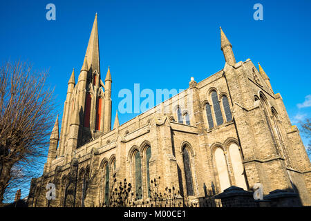 Tra i filari di bianco e rosso mattone case terrazza è William Rangers 1840 Victorian chiesa gotica di San Giovanni Evangelista. Bury St Edmunds, Suffolk Foto Stock