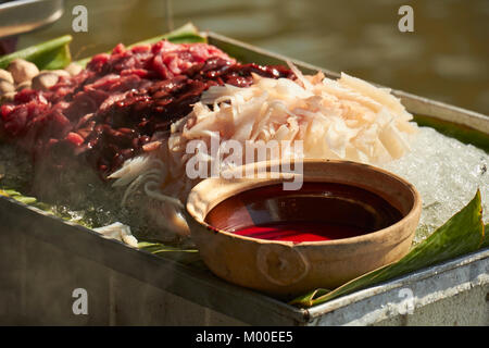 Carni e frattaglie pronta per la cottura in un mercato galleggiante a Bangkok, in Thailandia Foto Stock