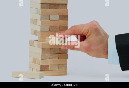 La torre da blocchi di legno e di mano d'uomo prendere un blocco. Foto Stock