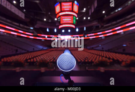 Un solitario microfono per il podio sul palco prima di un evento in un grande indor sports arena. Foto Stock