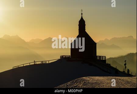 Rottach-Egern, Germania. Xiii gen, 2018. La cappella sul Wallberg la montagna sembra contro la retroilluminazione del sole di setting al Wallberg montagna vicino a Rottach-Egern, Germania, 13 gennaio 2018. Credito: Tobias Hase/dpa/Alamy Live News Foto Stock