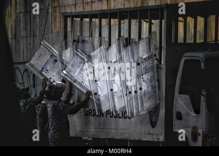 Caracas, Venezuela. Xvii gen, 2018. Funzionario di polizia visto tenendo gli scudi fuori dal loro carrello per proteggersi in caso di qualsiasi sommossa break out.funzionari della Guardia nazionale impedire che la gente e la stampa da vicino l'obitorio di Caracas. parenti dell'Ispettore Cicpc andato rogue, Oscar Perez, avvicinato il posto per cercare il corpo. L'ispettore è morto dopo una controversa operazione di polizia condotta dal governo di Nicolas Maduro, 7 persone sono morte con lui. Credito: Roman Camacho/SOPA/ZUMA filo/Alamy Live News Foto Stock