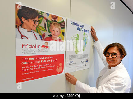 Hannover, Germania. 16 gennaio, 2018. Olga Kordonouri, medico in capo dei bambini e della gioventù ospedale Auf der Bult, riaggancia poster per la diagnosi precoce del diabete mellito di tipo 1 in corrispondenza dei bambini e della gioventù ospedale Auf der Bult ad Hannover, Germania, 16 gennaio 2018. Credito: Holger Hollemann/dpa/Alamy Live News Foto Stock