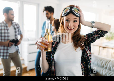 Gruppo di amici a suonare la chitarra e di festa a casa Foto Stock