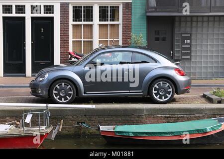 AMSTERDAM, Paesi Bassi - 7 Luglio 2017: Volkswagen New Beetle parcheggiata dal canale di Amsterdam. Paesi Bassi ha registrato 528 vetture per 1.000 inhabitan Foto Stock