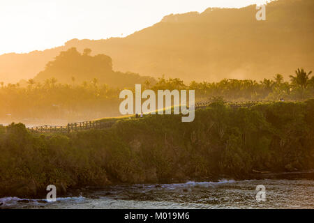 I turisti a piedi un percorso oceanside all'alba nella Repubblica Dominicana Foto Stock