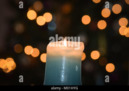 Candela che brucia con sfocata luce sfondo bokeh di fondo Foto Stock