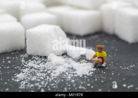 Persone in miniatura sweep up zucchero. Health care concetto. dieta, il grasso e il diabete. Health care concetto. Foto Stock