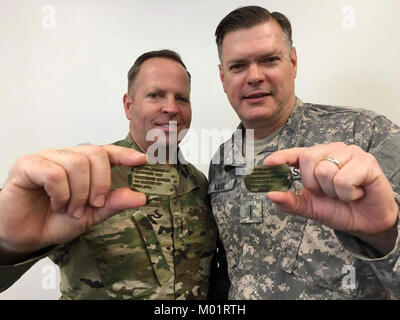 A sinistra, U.S. Army Chief Warrant Officer 2 Nathaniel Layton, 97th Transportation Company, 7° Brigata di trasporto (Expeditionary) chief engineer, E DEGLI STATI UNITI Army Chief Warrant Officer 5 Patrick può, ufficio del capo del capo del trasporto marittimo direttore di qualificazione, pone con il loro nonno, U.S. Esercito Cpl. Mervin Layton, dog tag a base comune Langley-Eustis, Virginia, Giugno 2016. Attualmente di stanza insieme, Layton e possono aiutare gli altri a crescere umanamente e professionalmente. ( Foto Stock