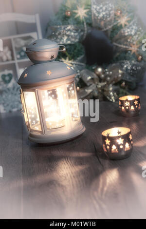 Lanterna decorativa, candele e decorazioni di Natale sulla cucina vintage. Questa immagine è tonica. Foto Stock