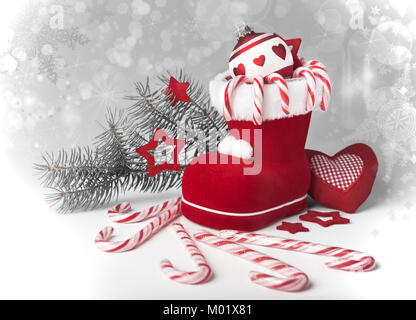 Santa's boot con candy canes e Xmas decorazioni su folle gradiente dello sfondo, spazio Foto Stock