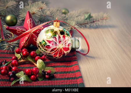 Disposizione di natale in rosso e verde su un tavolo di legno, lo spazio per il messaggio di saluto Foto Stock