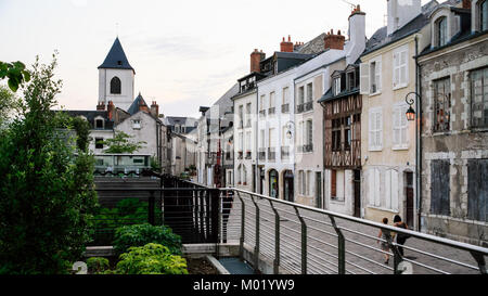 ORLEANS, Francia - 10 luglio 2010: la gente a piedi sulla strada Rue de la Charpenterie lungo vecchie case medievali e la vista della torre della chiesa Eglise Saint-Donat Foto Stock