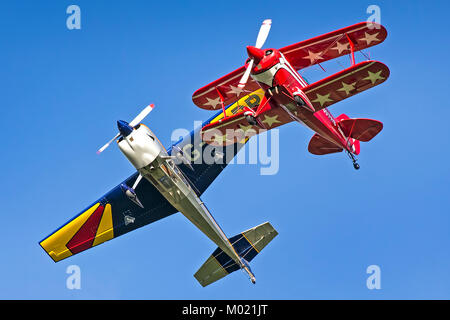 Due coloratissimi aeromobili di concorrenza tenendo-off insieme al 2013 Compton Abbas Airfield acrobazia giorno nel Wiltshire, Inghilterra Foto Stock