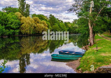 Valle del fiume Dordogne due barche ormeggiate nelle calme acque della Dordogna nel suo passaggio attraverso il villaggio di Carennac Francia Foto Stock