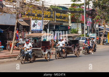 Strada tipica scena con tuk tuks e motocicli, Siem Reap, Cambidia Foto Stock