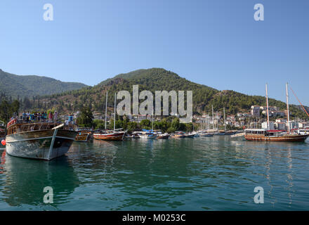 Vista di Fethiye costa con molte barche in luce del sole di mattina d'estate dal mazzo di piacere yacht, Turchia. Foto Stock