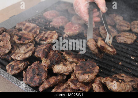 Le polpette di carne fresca, salsiccia e hot dog alla griglia all'aperto su un grill a gas. Le polpette di carne su un barbecue.In casa le polpette di carne e salsicce su una griglia elettrica. Foto Stock