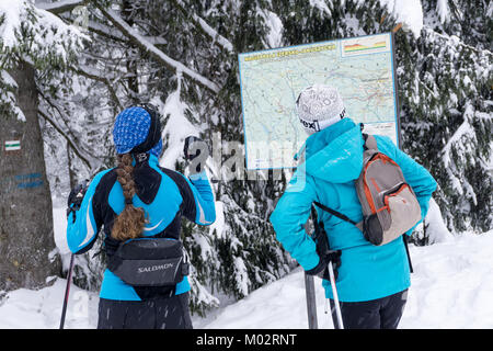 Due donne gli sciatori in cerca di un cross-country percorso sulla mappa. Jakuszyce, Giant Monti Karkonosze, Polonia, l'Europa. Foto Stock