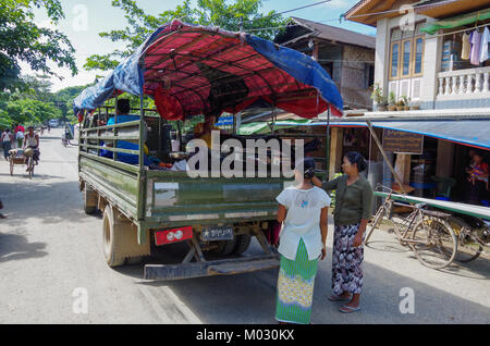 Mrauk-U, Stato di Rakhine / Myanmar - 18 Ottobre 2016: Le donne in attesa di un pickup nel mezzo della strada principale Foto Stock