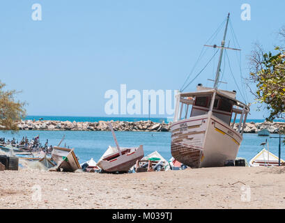 Barche da pesca attraccate al frangiflutti di la Guardia, in Spagna. Le barche sono allineate lungo il molo, pronte per la cattura del giorno successivo. Questa immagine cattura la tranquilla vita costiera nel piccolo villaggio di pescatori. Foto Stock