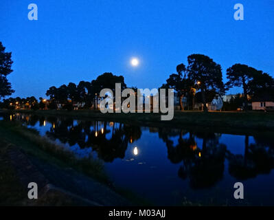 Una fotografia del canale Bydgoszcz in Polonia scattata la sera del 21 luglio 2014, che cattura il sereno riflesso della luna sull'acqua. Mette in risalto l'atmosfera tranquilla del canale. Foto Stock
