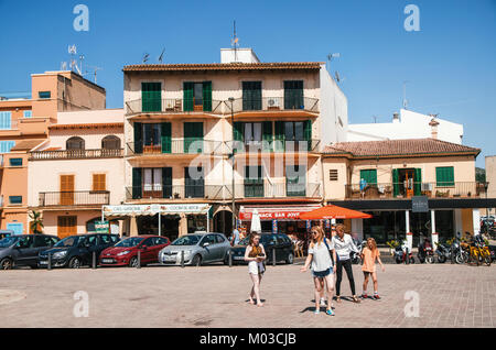 Alcudia, Mallorca, Spagna - 23 Maggio 2015: Famiglia di turisti percorrendo a piedi alla città storica di parte di Alcudia con la sua casa tradizionale e il cafe'. Carl Foto Stock