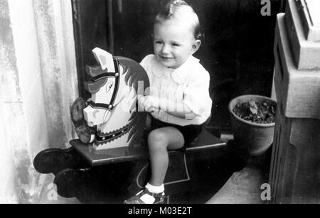 Bambino sul cavallo a dondolo Foto Stock