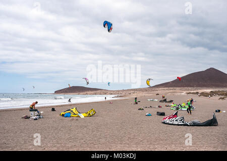 Kitesurfisti su El Médano spiaggia su un nuvoloso giorno ventoso, Tenerife, Spagna Foto Stock