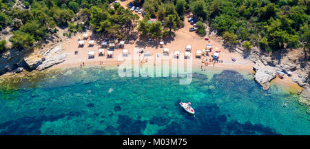 Vista aerea della spiaggia sabbiosa con bagni di sole turisti e chiaro mare turchese Foto Stock