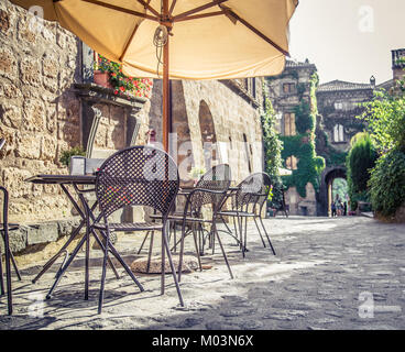 Cafe con tavoli e sedie in una vecchia strada in Europa con retro vintage stile Instagram effetto filtro Foto Stock