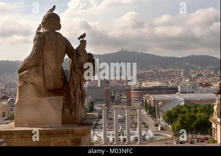 Una vista accattivante dello skyline di Barcellona da dietro una statua di pietra al Museo Nazionale d'Arte della Catalogna, che offre una prospettiva mozzafiato Foto Stock