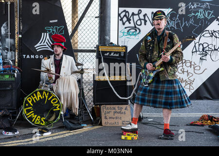 Le arti fantasma suonando la loro marca unica di punk rock e al di fuori della stazione di Shoreditch, London REGNO UNITO Foto Stock