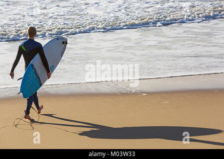 Bournemouth Dorset, Regno Unito. 18 gennaio, 2018. Regno Unito: meteo dopo una molto ventoso notte una bella giornata di sole a Bournemouth Beach. Surfer teste per il mare per rendere la maggior parte delle grandi onde e instabile dei mari. Surfer tenendo la scheda sulla riva del mare a piedi in mare e guardando le onde con ombra sulla sabbia. Credito: Carolyn Jenkins/Alamy Live News Foto Stock