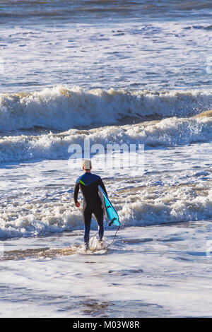 Bournemouth Dorset, Regno Unito. 18 gennaio, 2018. Regno Unito: meteo dopo una molto ventoso notte una bella giornata di sole a Bournemouth Beach. Surfer capi in mare per rendere la maggior parte delle grandi onde e instabile dei mari. Surfer tenendo la scheda Rubrica fuori in mare. Credito: Carolyn Jenkins/Alamy Live News Foto Stock