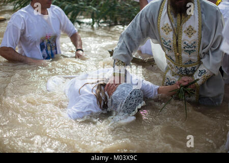 Jordan River Valley, vicino a Gerico, Territori palestinesi, 18 gennaio 2018. Un sacerdote battezza un cristiano ortodosso pellegrino durante la festa dell Epifania presso la West Bank sito battesimale di Qasr el Yahud, nella valle del Giordano, sulla sponda opposta a Gerico, Territori palestinesi, 18 gennaio 2018. Il sito è ritenuto dalle Chiese Orientali per essere la posizione originale del battesimo di Gesù da parte di Giovanni il Battista. Foto: Ilia Yefimovich/dpa Credito: dpa picture alliance/Alamy Live News Foto Stock