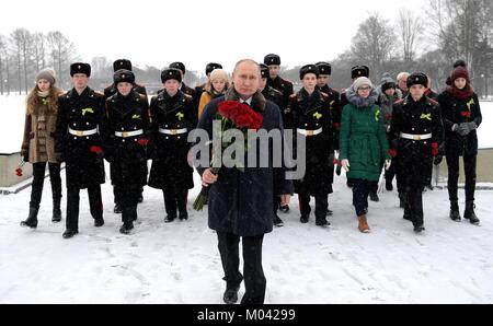 San Pietroburgo, Russia. 18 gennaio, 2018. Il presidente russo Vladimir Putin passeggiate con rose rosse durante una cerimonia che si terrà nel corso di una giornata nevosa presso il Cimitero di Piskarevskoye Gennaio 18, 2018 a San Pietroburgo, Russia. Putin ha partecipato gli eventi che segna il settantacinquesimo anniversario della fine della i nazisti assedio di Leningrado chiamato ora a San Pietroburgo. Credito: Planetpix/Alamy Live News Foto Stock