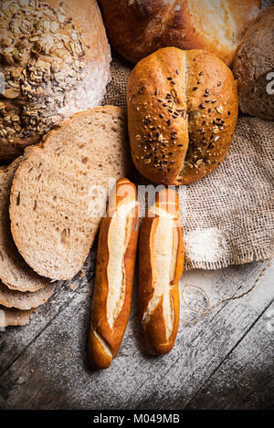 Diversi tipi di pane e panini sul tavolo di legno Foto Stock