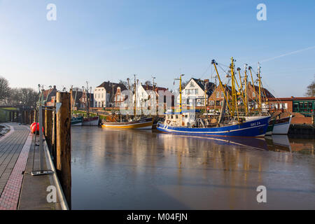 Il porto di pesca di Greetsiel, Frisia orientale, Ostfriesland, Bassa Sassonia, Germania, pescherecci con reti da traino adibiti alla pesca di gamberetti, shrimpcutter, nel porto, leggera copertura di ghiaccio sul w Foto Stock