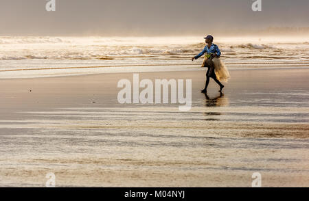 Bali Indonesia Ottobre 2015: Bali di pescatori lungo le rive di Yel Leh beach con la sua rete da pesca al tramonto, Indonesia Foto Stock