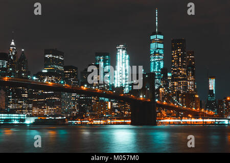 Il Ponte di Brooklyn, illuminato di notte, è uno dei monumenti più rappresentativi di New York cityâ. Si estende lungo l'East River, collegando Manhattan e Brooklyn, ed è conosciuta per il suo impressionante design architettonico e il suo significato storico. Foto Stock