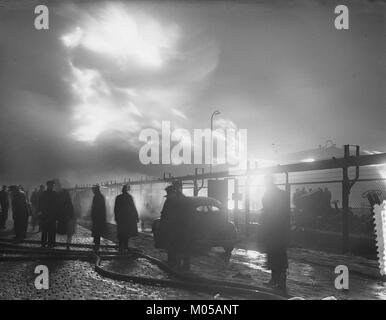 Questa immagine raffigura una scena di un incendio nella raffineria di Pernis, parte degli impianti della Royal Dutch Shell nei Paesi Bassi. Il fuoco è stato un evento industriale significativo nella regione, che ha colpito le operazioni in una delle più grandi raffinerie d'Europa. Foto Stock