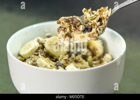 La colazione idea ciotola di cerial muesli con fette di banana e latte uno dei cinque al giorno di frutta e carboidrati per il lento rilascio di energia ed è bello Foto Stock