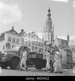 La fotografia mostra un gruppo di giovani di Breda, Paesi Bassi, che lavorano come spazzatrici di strada, probabilmente come parte di un lavoro estivo o di un'iniziativa comunitaria. L'immagine riflette la storia dell'occupazione giovanile e delle pratiche sociali all'inizio del XX secolo a Breda. Foto Stock