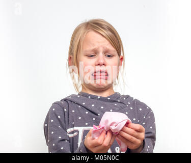 Bambina guarda disgustato nel fazzoletto usato Foto Stock