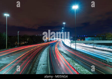 Vista notturna di traffico su autostrada M8 durante le giornate di cattivo tempo nella zona centrale di Glasgow, Scotland, Regno Unito. Foto Stock