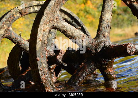 Metallo arrugginito ruote in un lago Foto Stock