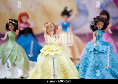 Pochi personaggi Disney bambole usata come cake topper su una torta di compleanno per una celebrazione Foto Stock