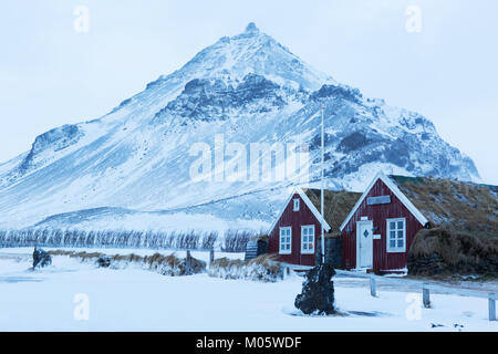 Tappeto erboso islandese case in Arnarstapi. Arnarstapi o Stapi è un piccolo villaggio di pescatori, Snaefellsnes, Islanda. Foto Stock